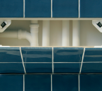 Open blue tiled access panel showing plastic pipework behind