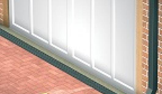 Hose with water running towards drainage channel installed in front of white garage door
